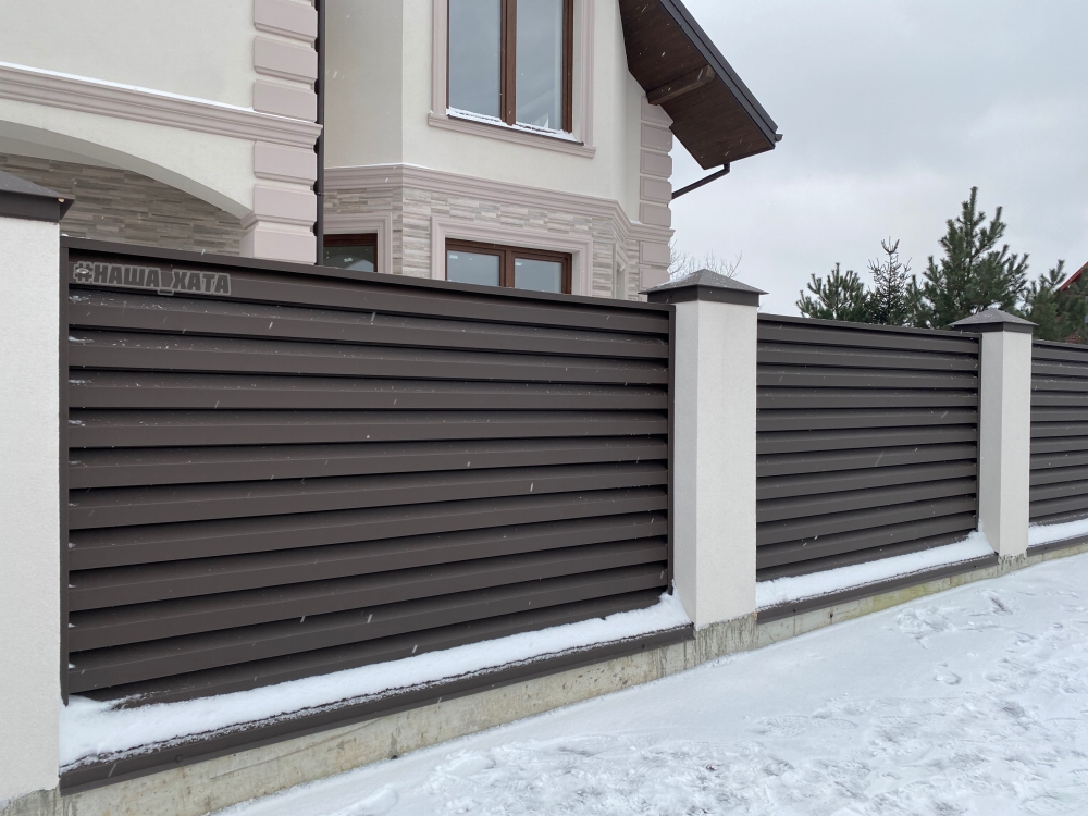 Красивий паркан жалюзі з білосніжними стовпами